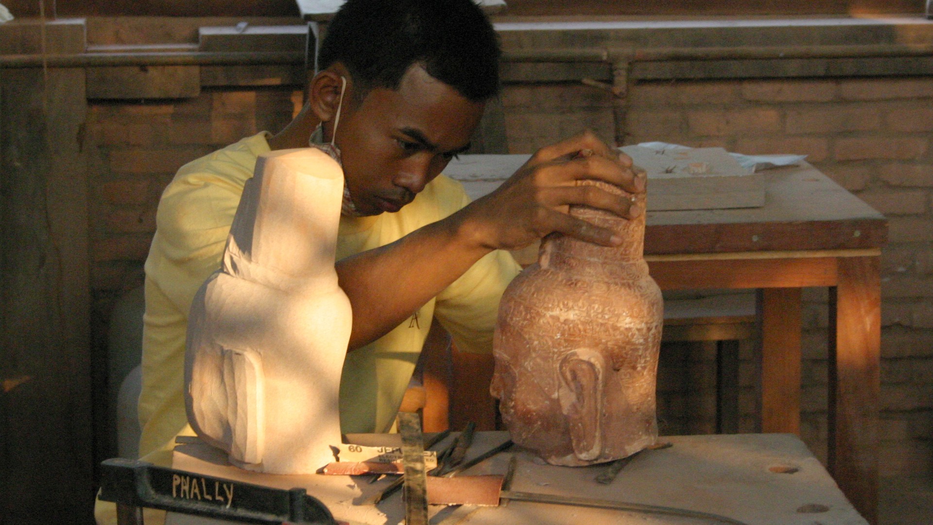 Artisan carving a decorative form from stone